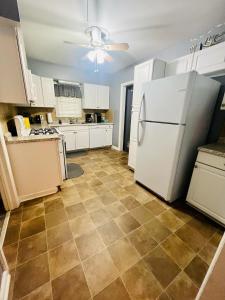 cocina con nevera blanca y suelo de baldosa en Center City Family Getaway, en Columbus