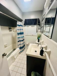 Un baño con lavabo, inodoro y bañera. en Center City Family Getaway, en Columbus