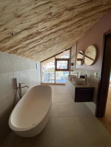 un bagno con una grande vasca bianca e due lavandini di Face d'Or a Zermatt