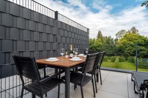 a table with chairs and wine glasses on a patio at Exklusiv Appartement - Jacuzzi Grens van Enschede! in Gronau