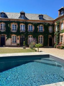 a large house with a swimming pool in front of it at Gîte en Normandie avec piscine in Rugles