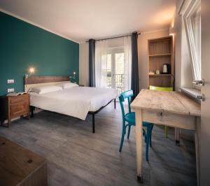 une chambre avec un lit, une table et un bureau dans l'établissement l'Oura B&B, à Challand Saint Anselme