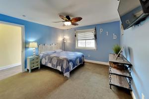 a blue bedroom with a bed and a ceiling fan at Put-in-Bay Waterfront Condo #107 in Put-in-Bay