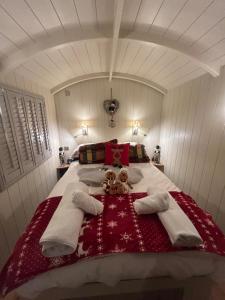 a bedroom with a bed with two teddy bears on it at Cotswold Shepherd hut Hot Tub sauna Dog friendly in Charlton