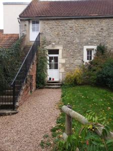 a brick house with a white door and a yard at La Ferme du BoisDieu in Avallon