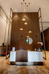 a lobby with a reception desk in front of a wooden wall at One Lux Stay Grande Signature Residences in Dubai +90 photos