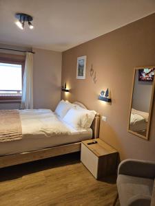 リヴィーニョにあるDany Lodge Snow & Funのベッドルーム1室(ベッド1台、鏡、椅子付)