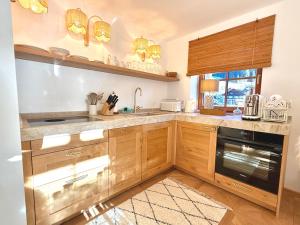 a kitchen with wooden cabinets and a sink at SEIN Boutique Suites - ADULTS ONLY in Gosau
