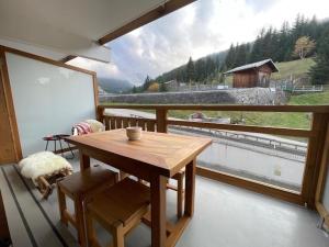 a room with a wooden table and a large window at Le 104 La Reserve Courchevel, Ski aux pied in Courchevel +12 photos