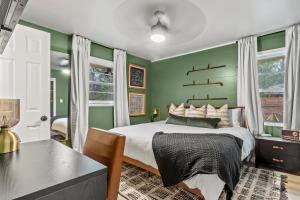 a bedroom with green walls with a bed and a desk at NEW 5 Star Luxury-Masters-Hot Tub-Fire Pit-EV Char in Augusta