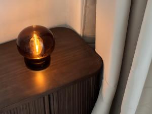 a light on a wooden table next to a window at Martha's House in Alba Iulia