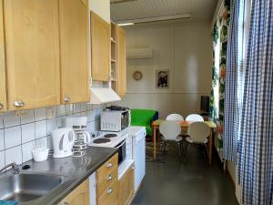 a kitchen with a sink and a table with chairs at Koveron Majatalo in Kovero