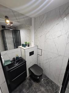a bathroom with a black toilet and a sink at LUXURY GREEN APARTMENT by Marta in Radom