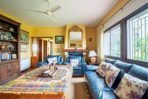 a living room with a blue couch and a fireplace at Casa de campo con piscina junto a Sevilla in Mairena del Alcor