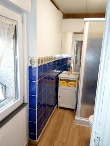 a small kitchen with blue tiled walls and a sink at Casa Cernuda in Ferrera de los Gabitos +40 photos