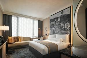 a hotel room with a large bed and a couch at Hotel Stripes Kuala Lumpur, Autograph Collection in Kuala Lumpur