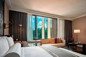 a hotel room with a bed and a large window at Hotel Stripes Kuala Lumpur, Autograph Collection in Kuala Lumpur