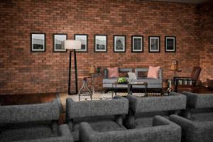 a living room with couches and a brick wall at Hotel Stripes Kuala Lumpur, Autograph Collection in Kuala Lumpur
