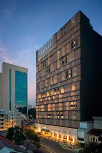 a tall building with lights on in a city at Hotel Stripes Kuala Lumpur, Autograph Collection in Kuala Lumpur