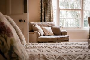 a bedroom with a couch and a chair and a window at Gallows Hill in Scarborough