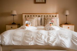 two stuffed swans are sitting on a white bed at Gallows Hill in Scarborough