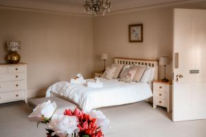 a bedroom with a bed with white sheets and flowers at Gallows Hill in Scarborough