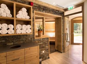 kuchnia z kamienną ścianą i półkami z płytami w obiekcie Bachmann Appartements w mieście Sankt Anton am Arlberg
