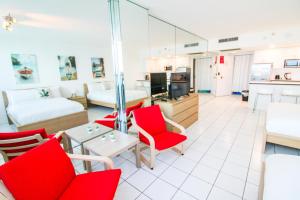 sala de estar amplia con sillas rojas y sofá en Castle 1133 Ocean view studio, Pool and Beach Access, FREE Parking, Tennis and more!, en Miami Beach