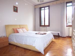 a bedroom with a large bed and two windows at Bella Vista Apartment in Venice