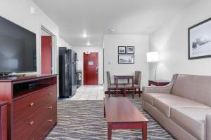 a living room with a couch and a tv at Cobblestone Hotel & Suites - Lynden in Lynden