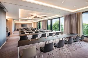 a conference room with tables and chairs and a screen at Le Méridien Hamburg in Hamburg +85 photos
