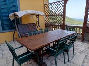 a wooden table with chairs and an umbrella on a patio at Residenza 1898 in Rocca di Papa