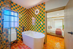 a bathroom with a bath tub and a bedroom at Hotel Casona Quetzal in Guadalajara