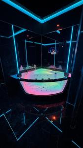 una grande vasca da bagno in una stanza con luci blu e rosa di BDSM room Bydgoszcz z Balią a Bydgoszcz