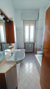 a bathroom with two sinks and a tub and two toilets at La casa di Davide in Imola