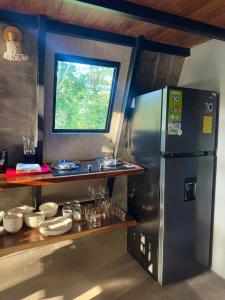 a kitchen with a stainless steel refrigerator and a window at Chalet de los ciervos in Isla Cabuya +22 photos