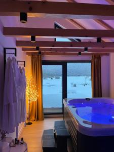 a large bathroom with a tub and a large window at Liko Diko Holiday Home in Gospić