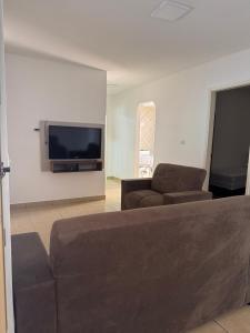 a living room with a couch and a flat screen tv at Casa Aconchego Itaici in Caldas Novas
