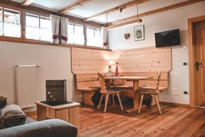 a living room with a table and chairs and a television at Kerschbaumhof in San Candido