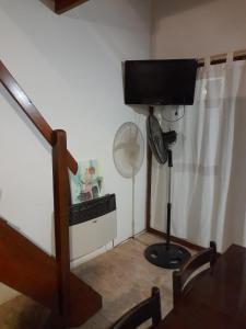 a room with a fan and a television in a room at Departamento 3 ambientes, para 4 personas, barrio tranquilo a una cuadra del bosque in Pinamar