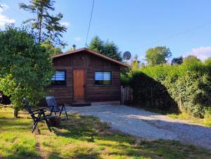 a cabin with a bench in front of it at Cabañas San Agustín in Panguipulli