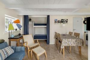 NeksøにあるCozy Holiday Home On Sydbornholmのテーブルと椅子とソファのあるリビングルーム