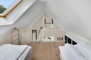 NeksøにあるCozy Holiday Home On Sydbornholmの屋根裏のベッドルーム(ベッド2台、階段付)