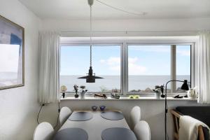 a living room with a table in front of a window at Holiday Apartment On The Bornholm Cliffs in Allinge