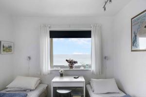 a bedroom with two beds and a window with a view at Holiday Apartment On The Bornholm Cliffs in Allinge