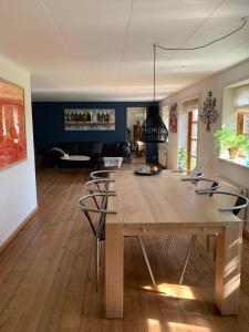 a dining room with a large wooden table and chairs at Idyllic Country House On Bornholm in Neksø