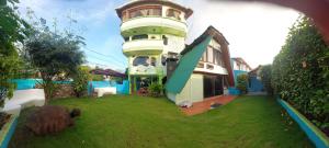 a large building with a grass yard in front of it at Hostal Casa Edén in Puerto Ayora