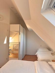 a attic bedroom with two beds and a mirror at Traumhaft moderne Ferienhaus-Tiny House in 78554 Aldingen in Aldingen