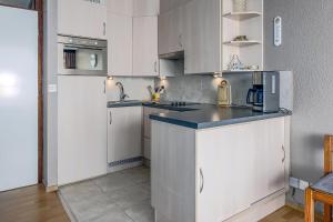 a kitchen with white cabinets and a blue counter top at Hermes 3-0505 P in Sint-Idesbald +10 photos