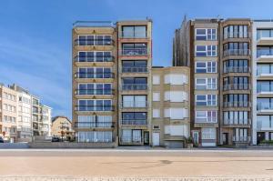 an apartment building in front of some buildings at Horizon 0501 P in Sint-Idesbald